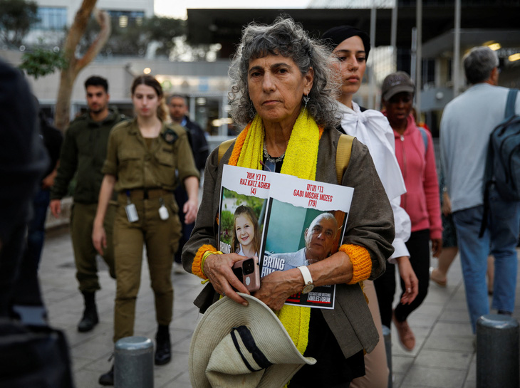 Tại Tel Aviv (Israel), một người cầm tấm biển kêu gọi trả tự do cho các con tin bị Hamas bắt giữ - Ảnh: REUTERS