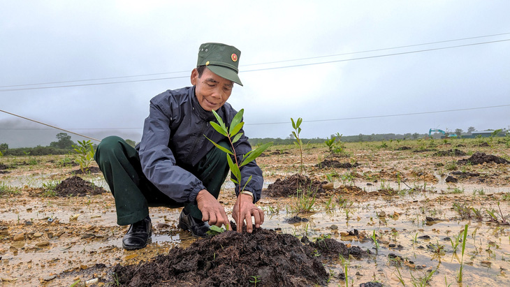Cựu binh Hồ Văn Tuồn trồng những mầm xanh đầu tiên trên vùng đất chết được hồi sinh ở sân bay A So - Ảnh: NHẬT LINH