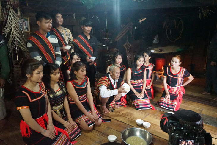 Già làng ngồi giữa các thanh niên, cô gái Ca Dong trong làng để dặn dò - Ảnh: P.T.