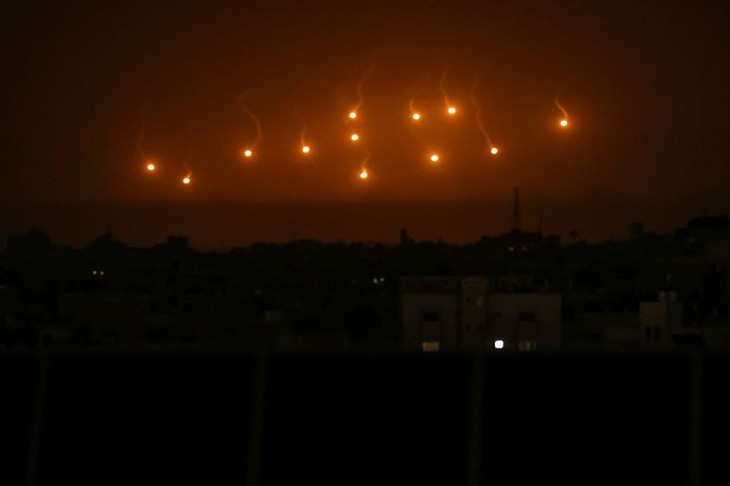 Israel thả pháo sáng khắp bầu trời thành phố Khan Younis ở phía nam Dải Gaza để hỗ trợ cuộc không kích rạng sáng 23-11 tại đây - Ảnh: AL JAZEERA