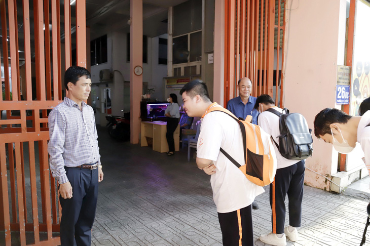 Thầy giám thị Trần Quốc Dương đón học sinh vào trường vào mỗi buổi sáng - Ảnh: NHƯ HÙNG