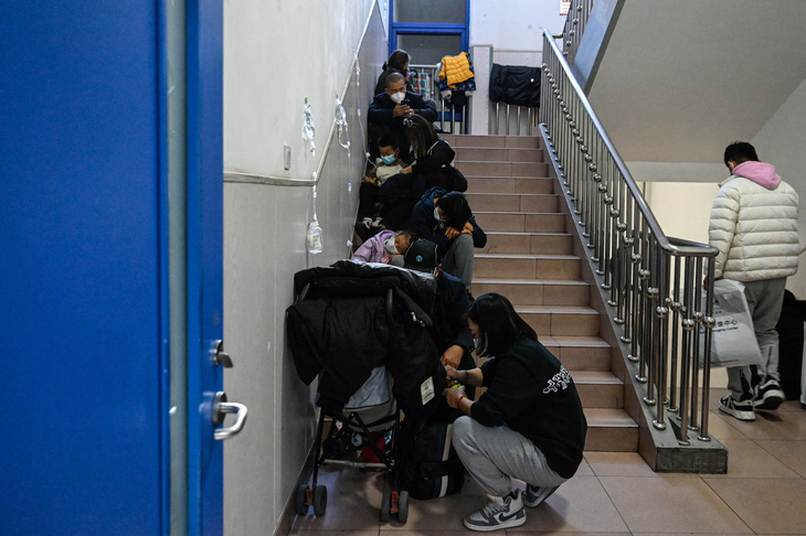 Bệnh viện quá tải khiến nhiều trẻ em và bệnh nhân phải truyền dịch ngay lối đi tại bệnh viện ở Bắc Kinh, Trung Quốc, ngày 23-11 - Ảnh: AFP