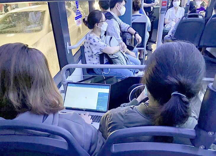 Khách ngồi làm việc có WiFi miễn phí khi đi xe buýt điện D4 - Ảnh: NGỌC HÀ