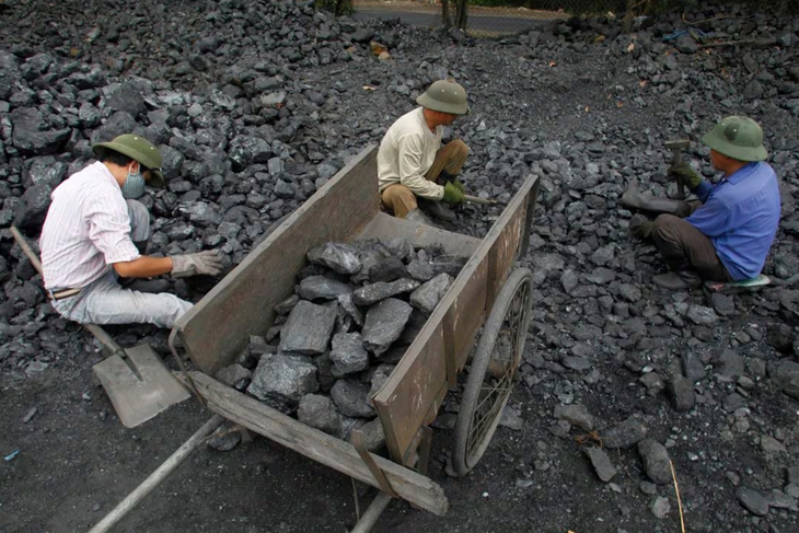 Công nhân đang tách sỏi khỏi than đá tại một mỏ than ở Hà Nội - Ảnh: REUTERS