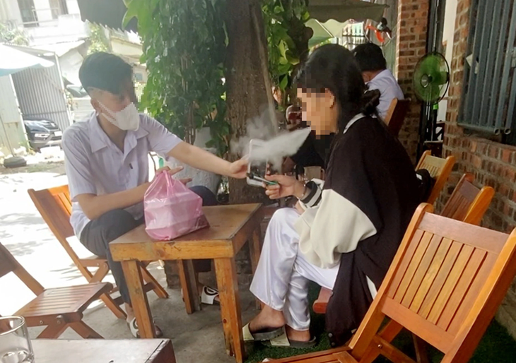 Nữ sinh một trung tâm giáo dục thường xuyên ở Đà Nẵng hút thuốc lá điện tử trong giờ trưa tại quán cà phê - Ảnh: B.D.