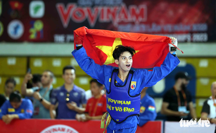 VĐV Lê Nguyễn Hoài Nam cầm cờ Tổ quốc ăn mừng sau khi giành HCV đối kháng - Ảnh: N.K
