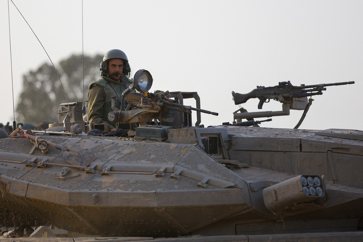 Binh sĩ Israel ngồi trên xe tăng gần biên giới Gaza - Israel trong ngày ngừng bắn 26-11 - Ảnh: REUTERS