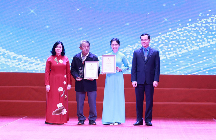 Bà Bùi Thị Minh Hoài - trưởng Ban Dân vận Trung ương và ông Nguyễn Đình Khang - chủ tịch Tổng liên đoàn Lao động Việt Nam - trao giải nhất cho các tác giả - Ảnh: HẢI NGUYỄN