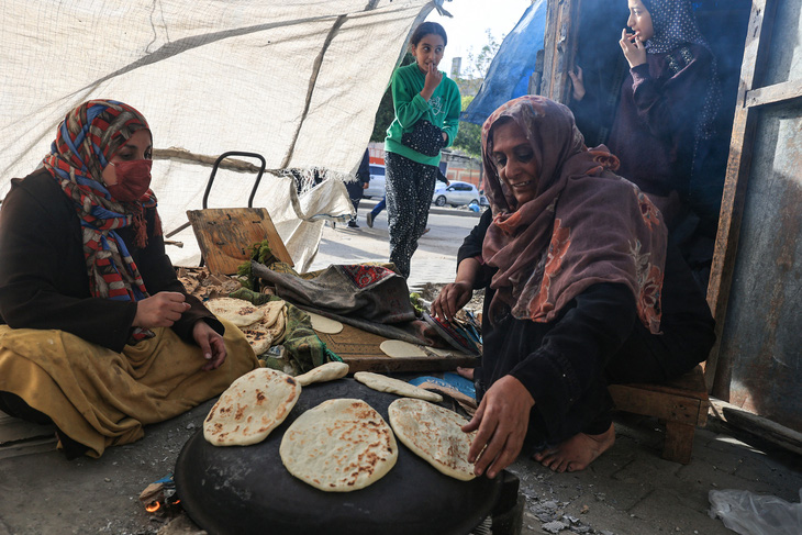 Phụ nữ Palestine nướng bánh mì bằng bếp củi tự chế ở Rafah, phía Nam Gaza, ngày 25-11 - Ảnh: AFP
