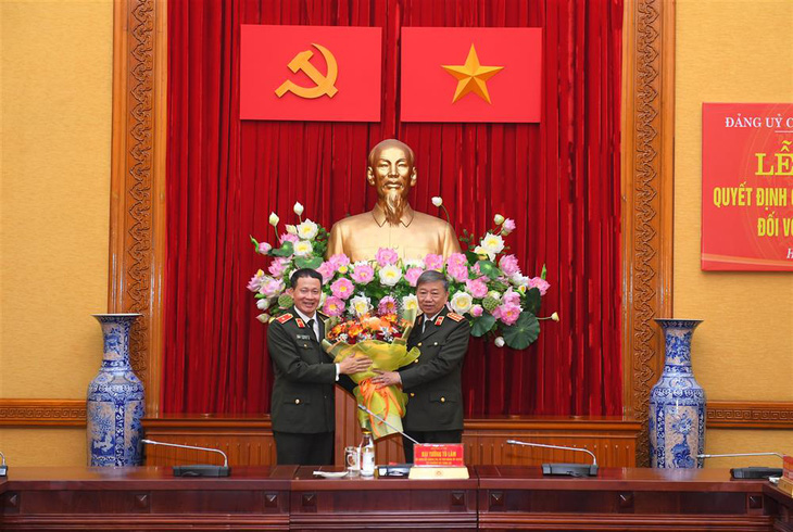 Bộ trưởng Tô Lâm tặng hoa chúc mừng thiếu tướng Vũ Hồng Văn - Ảnh: Bộ Công an