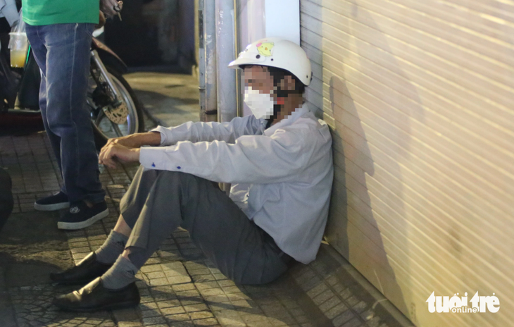 Người đàn ông có biểu hiện say xỉn ngồi bệt xuống đất để đối phó với cảnh sát giao thông, không chấp hành đo nồng độ cồn - Ảnh: MINH HÒA