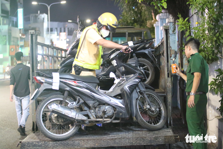 Cảnh sát tạm giữ xe máy người vi phạm - Ảnh: MINH HÒA