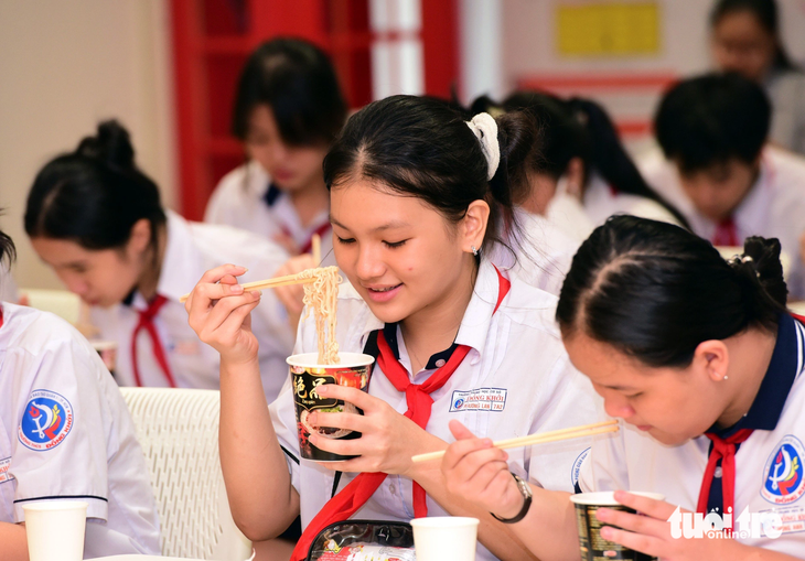 Em Phương Lan (học sinh lớp 7A2, Trường THCS Đồng Khởi, quận 1, TP.HCM) thích thú thưởng thức mì - Ảnh: DUYÊN PHAN