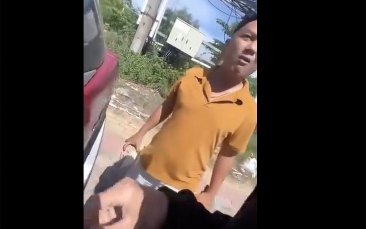 Cán bộ cảnh sát giao thông cầm viên gạch trong tay dọa đánh người - Ảnh cắt từ clip