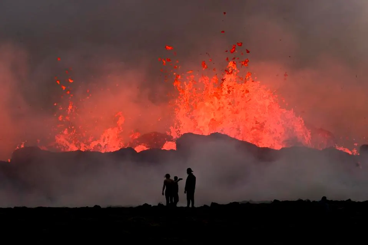 Người dân đứng nhìn dung nham chảy trong một vụ phun trào núi lửa gần Litli Hrutur, phía tây nam Reykjavik, Iceland vào ngày 10-7-2023 - Ảnh: AFP/GETTY IMAGES