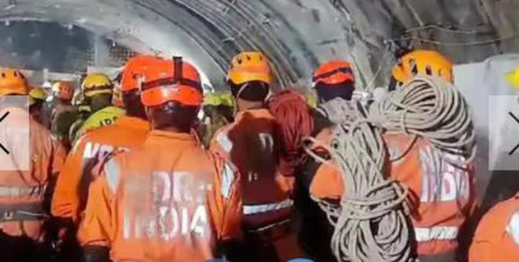 Nhân viên cứu hộ chờ trước đường ống thoát hiểm - Ảnh: TIMES OF INDIA
