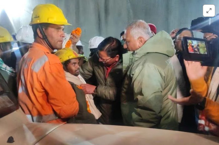 Thủ hiến bang Uttarakhand Pushkar Singh Dhami - người có mặt tại địa điểm cứu hộ trong suốt những ngày qua - hỏi han nam công nhân đầu tiên được giải cứu - Ảnh: REUTERS