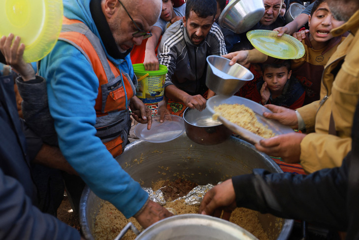Người dân Palestine nhận thực phẩm cứu trợ ở miền nam Dải Gaza ngày 30-11 - Ảnh: AFP