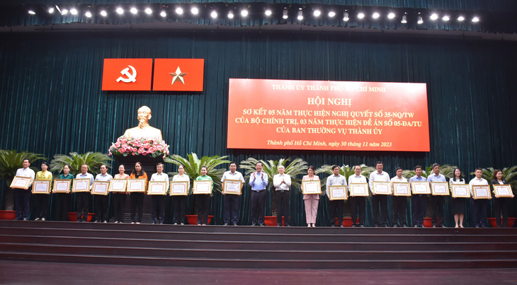 Chủ tịch UBND TP Phan Văn Mãi và Trưởng Ban Tuyên giáo Thành ủy TP Phan Nguyễn Như Khuê trao bằng khen cho các tập thể, cá nhân - Ảnh: TIẾN LONG