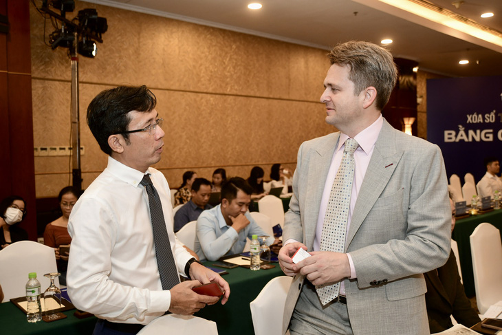 Ông Trần Xuân Toàn - phó tổng biên tập báo Tuổi Trẻ trao đổi cùng ông Marcin Figlus - giám đốc khối quản trị rủi ro FE Credit bên lề hội thảo - Ảnh: QUANG ĐỊNH