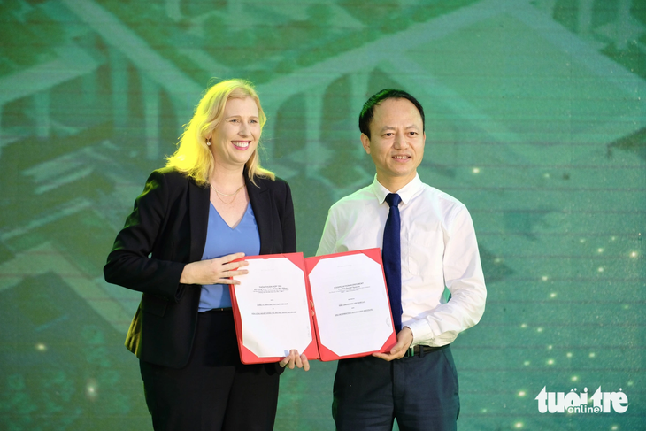Đại diện Đại học Quốc gia Hà Nội nhận biểu trưng cam kểt đầu tư của doanh nghiệp - Ảnh: NGUYÊN BẢO