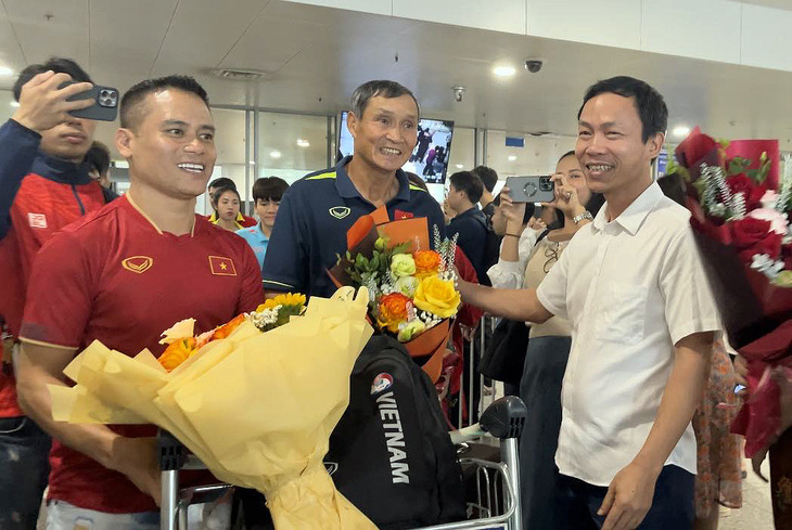 HLV Mai Đức Chung được chào đón tại sân bay Nội Bài - Ảnh: VFF
