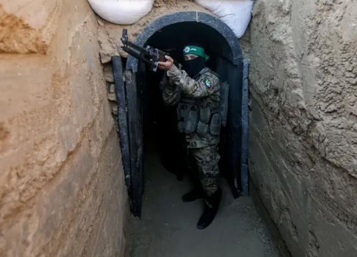 Một chiến binh của Izz al-Din al-Qassam đứng trước một đường hầm trong cuộc triển lãm vũ khí, tên lửa và thiết bị hạng nặng cho cánh quân sự của Hamas - Ảnh: SOPA IMAGES