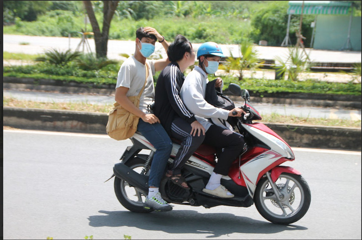 Một nhóm sinh viên chở ba khi chạy xe máy - Ảnh: THU GIANG