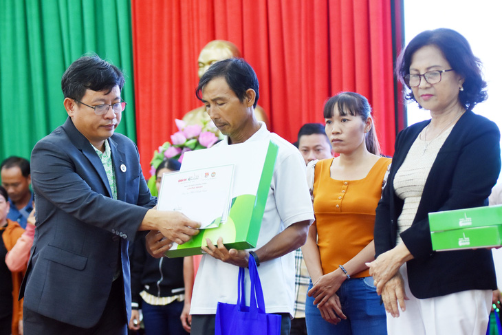 Ông Phùng Bửu Quang, giám đốc điều hành Công ty cổ phần GREENFEED Việt Nam chi nhánh Đồng Nai (bìa trái), trao vốn cho nông dân khó khăn - Ảnh: A LỘC