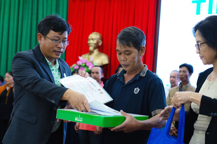 Ông Phùng Bửu Quang, giám đốc điều hành Công ty cổ phần GREENFEED Việt Nam chi nhánh Đồng Nai (bìa trái), trao vốn cho nông dân khó khăn - Ảnh: AN BÌNH