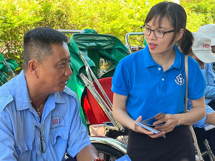 Cán bộ của Bảo hiểm xã hội tỉnh Quảng Nam tư vấn chính sách bảo hiểm xã hội tự nguyện cho người chạy xích lô tại khu vực phố cổ Hội An - Ảnh: HỒNG HÀ