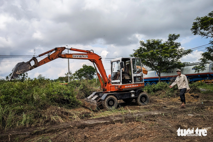 Xe múc đang triển khai san gạt mặt bằng khu đất công trên đường Đinh Văn Chất, xã Hòa Phước, để làm bãi xe - Ảnh: TẤN LỰC 