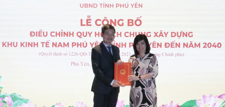 Đại diện Bộ Xây dựng trao quyết định của Thủ tướng Chính phủ về điều chỉnh quy hoạch xây dựng Khu kinh tế Nam Phú Yên cho chủ tịch UBND tỉnh Phú Yên Tạ Anh Tuấn - Ảnh: VĂN VINH