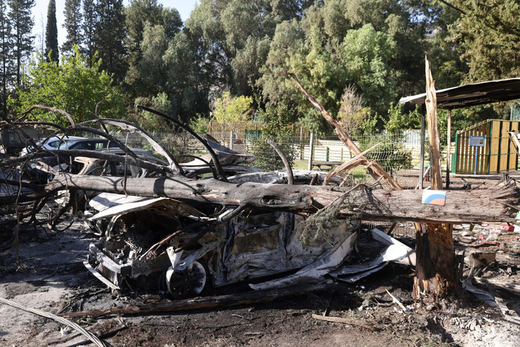 Ô tô bị hư hại và cây bị đổ ở thành phố Kiryat Shmona - Ảnh: AFP