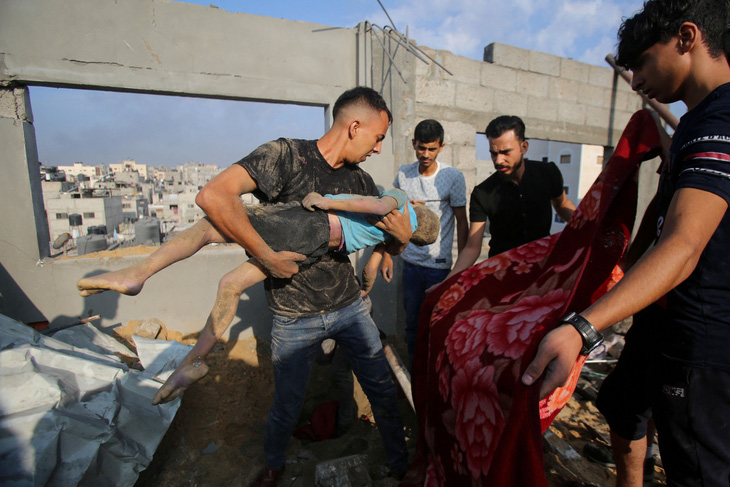 Người dân Palestine tìm thấy thi thể một đứa trẻ sau cuộc không kích của Israel nhắm vào trại tị nạn Jabalia hôm 1-11 - Ảnh: AFP