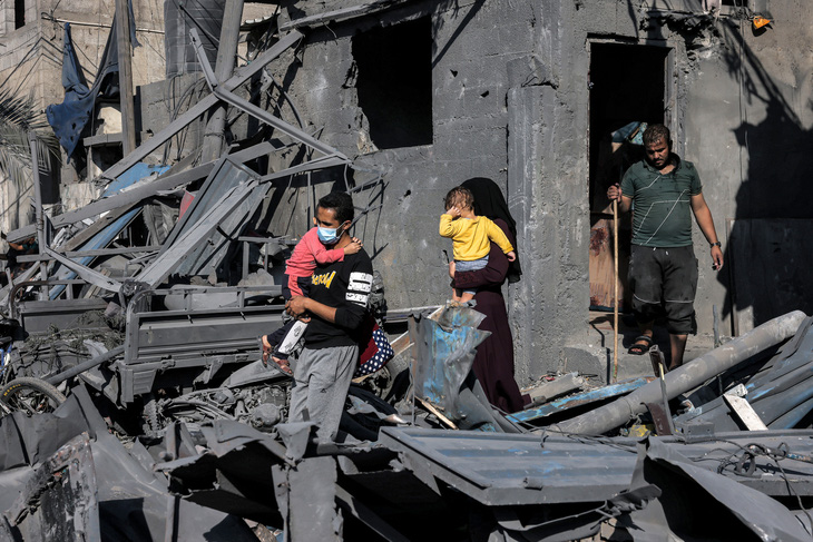 Người dân đưa trẻ em ra khỏi đống đổ nát ở phía Nam Gaza, ngày 31-10 - Ảnh: AFP
