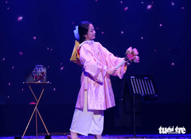 Cát Tường gây ấn tượng với hình ảnh em bé Việt Nam xinh xắn trong chiếc áo dài màu hồng, chân mang guốc mộc, đầu đội nón lá, tay cầm một bó hoa sen - Ảnh: LINH ĐOAN