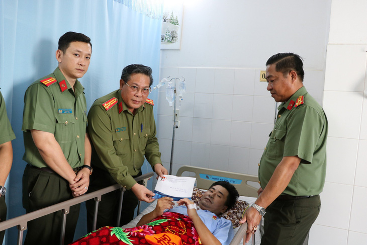 Công an tỉnh Kiên Giang đến thăm và trao phần quà với số tiền gần 200 triệu đồng cho đại úy Ngôi điều trị vết thương, sớm về với gia đình - Ảnh: QUỐC TRƯƠNG