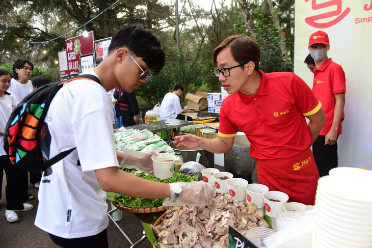 Hoa hồi vàng Nguyễn Tự Tin ( Phở ‘S) hướng dẫn tình nguyện viên cách làm một tô phở để phục vụ khách - Ảnh: DUYÊN PHAN