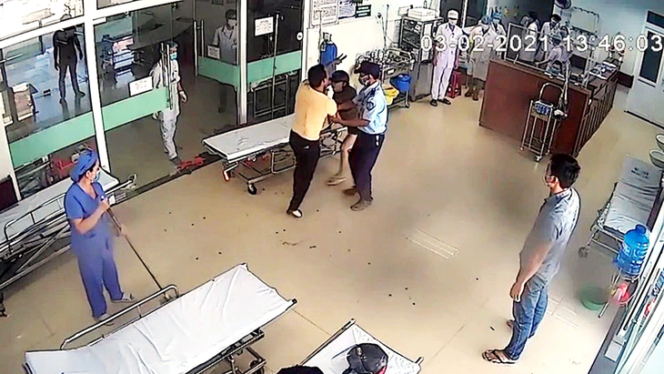 Một bệnh nhân được bảo vệ bệnh viện giữ lại khi hành hung bác sĩ - Ảnh: cắt từ clip