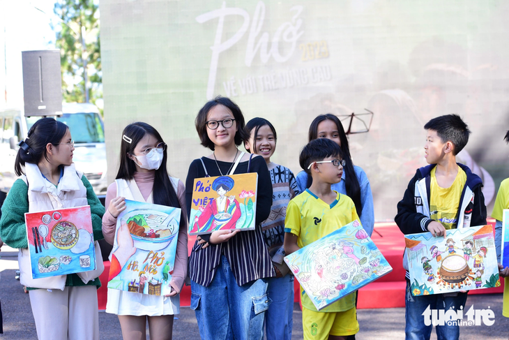 Các em nhỏ nhóm Ô cửa sách tặng tranh cho ban tổ chức chương trình cộng đồng Ngày của phở 12-12 - Ảnh: DUYÊN PHAN