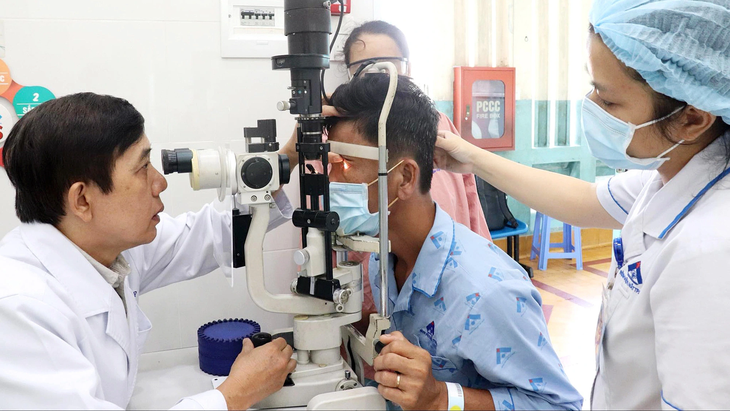 Bác sĩ Trang Thanh Nghiệp - trưởng khoa glaucoma Bệnh viện Mắt TP.HCM - thăm khám thị lực cho bệnh nhân bị mù mắt phải vì mắc bệnh cườm nước nhưng không điều trị kịp thời - Ảnh: XUÂN MAI