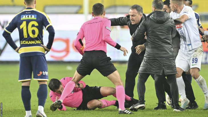 Trọng tài Meler té ngã xuống sân nhưng vẫn bị đá tới tấp - Ảnh: Getty