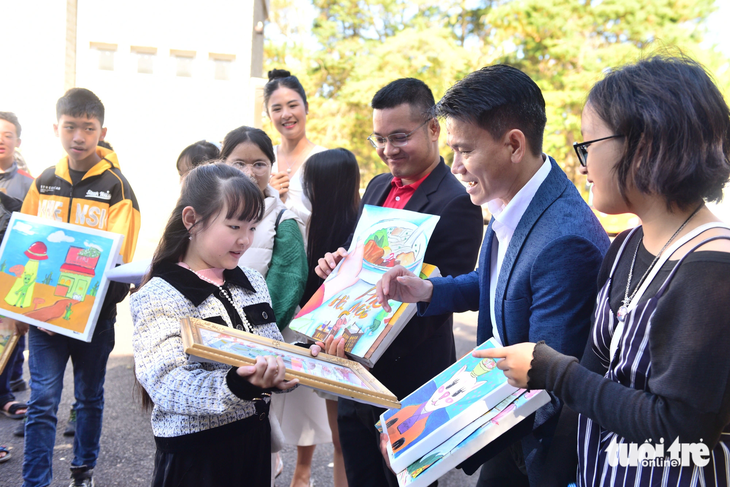Đại diện nhà tài trợ Acecook và báo Tuổi Trẻ nhận tranh tặng từ các em nhỏ nhóm Ô Cửa Sách