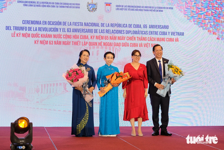 Tổng lãnh sự Cuba tại TP.HCM Ariadne Feo Labrada tặng hoa cho Chủ tịch UBND TP.HCM Phan Văn Mãi và khách dự sự kiện ngày 12-12 - Ảnh: TRẦN PHƯƠNG