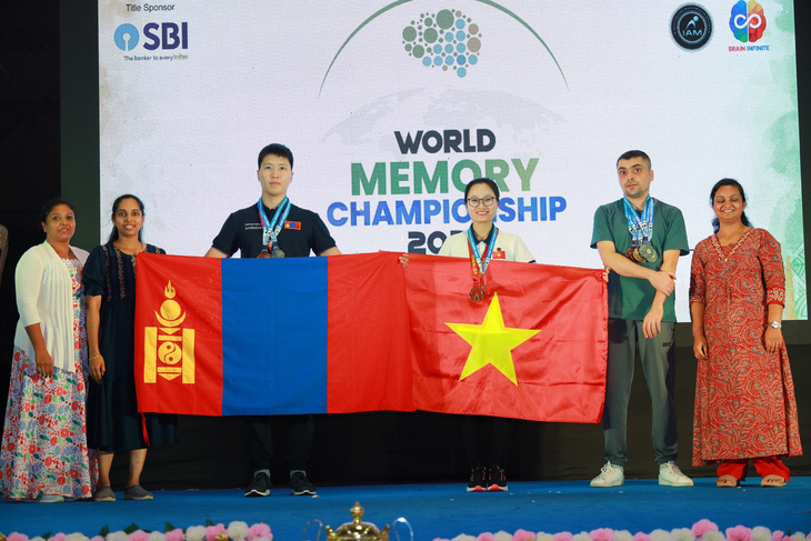Đặng Ngọc Phương Trinh (thứ 3 từ phải sang) nâng cao quốc kỳ sau khi giành huy chương vàng tại cuộc thi siêu trí nhớ thế giới 2023 tại Ấn Độ - Ảnh: NVCC