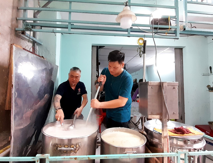 Anh Hà Ngọc Lâm (bìa trái) cùng anh Hồ Văn Tài, cơ trưởng một hãng hàng không có sức khỏe, trực tiếp đứng bếp khuấy các nồi cháo to