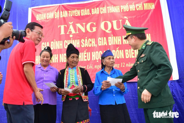 Chủ tịch Hội Nhà báo TP.HCM Nguyễn Tấn Phong, đại tá Vừ A Khua trao quà cho ba gia đình chính sách, người có công của xã Mường Lói - Ảnh: T.T.D.