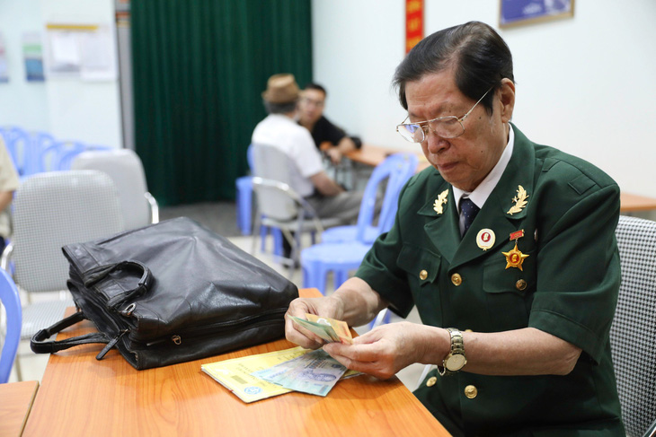 Người dân nhận lương hưu tại một điểm chi trả do nhân viên bưu điện phụ trách tại quận Đống Đa, Hà Nội - Ảnh: DANH KHANG