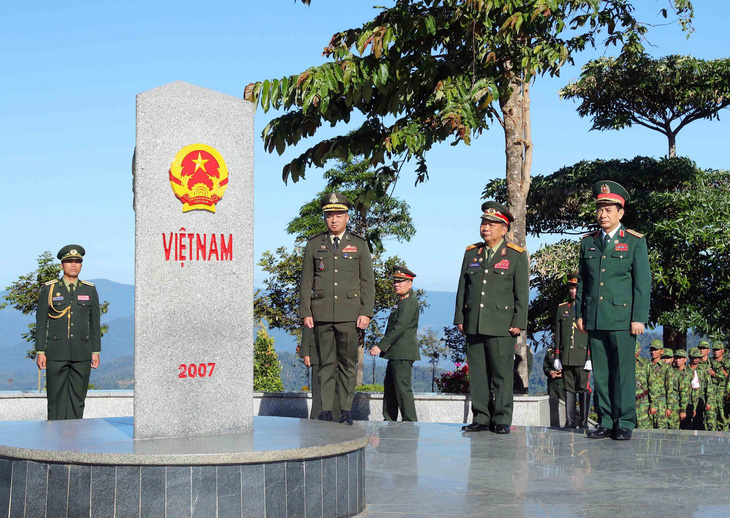 Ba bộ trưởng quốc phòng Việt Nam - Lào - Campuchia đã chào và tô son cột mốc chủ quyền - Ảnh: ĐÌNH CƯƠNG